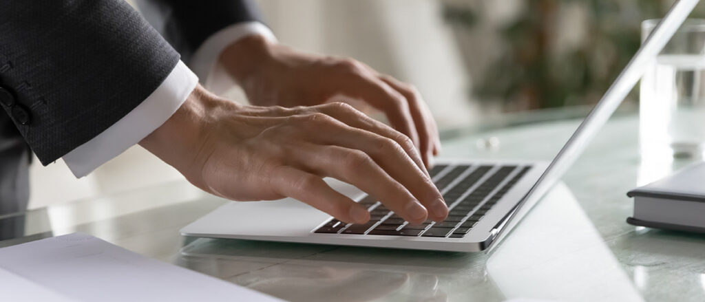 Panoramic banner wide view of successful male CEO typing on modern laptop keyboard, browse internet in office, confident businessman text message check mail on computer gadget, technology concept