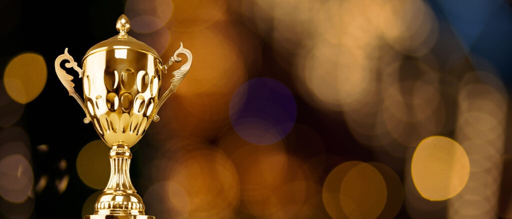 Golden metal trophy cup. Festive light background