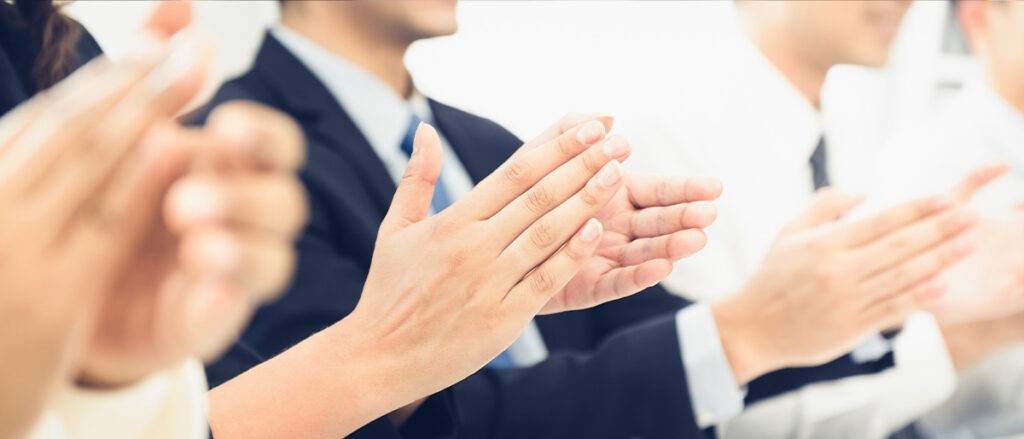 Group of business people clapping their hands at the meeting